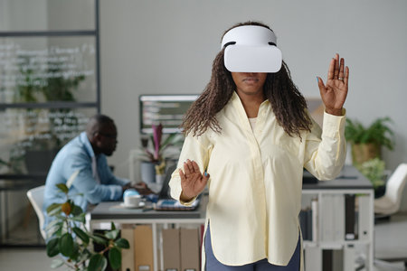 African American woman enjoying VR game in office of modern game developing company