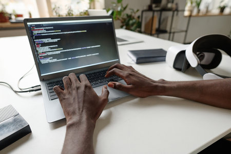 Unrecognizable male hands typing on keyboard, eclectic devices on top of work deskの写真素材
