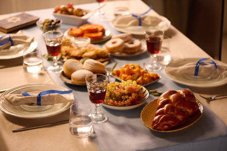 High angle shot of fresh baked pastries, fruit and glasses with red wine on table in dining room before celebrationの写真素材