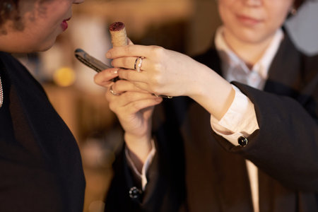 Medium close up of unrecognizable female customer smelling wine cork on corkscrew in hands of unrecognizable sommelierの写真素材