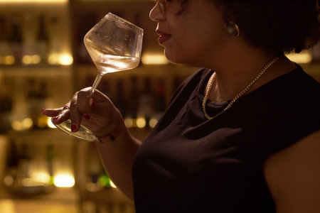 Medium close up of unrecognizable woman smelling wonderful scent of wine while tastingの写真素材