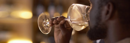 Website banner with unrecognizable African American highly skilled sommelier drinking white wine to check its tasteの写真素材