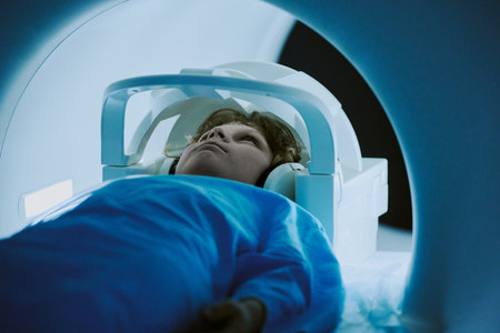 Caucasian child lying inside MRI scanner undergoing medical imaging procedure, wearing headphones...