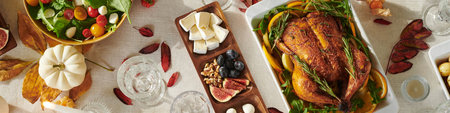 Roast turkey garnished with herbs surrounded by autumn leaves, salad with cherry tomatoes and...