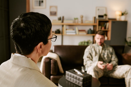 Caucasian middle aged woman with short hair and glasses conducting therapy session with Caucasian...