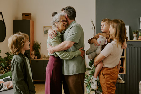 Middle aged Caucasian man hugging senior mother while his wife holding child with stuffed animal and...
