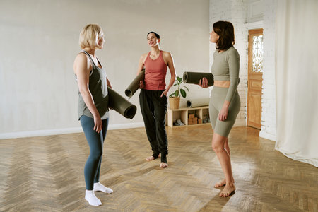 Three young adult women, including two Caucasian and one possibly Hispanic, standing barefoot...