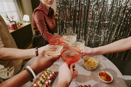 Group of young adult and middle aged multiethnic men and women raising glasses in celebration,...