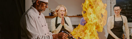Website banner of chef demonstrating flambe technique while women observing in cooking class kitchen...