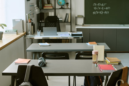 Empty classroom with students study materials arranged on desks, suggesting active learning and school education. Ideal for academic marketing, tutoring, enrollment campaigns
