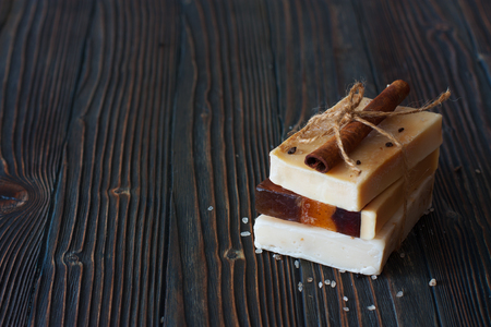 Bars of handmade soap and sea salt over natural wood backgroundの写真素材
