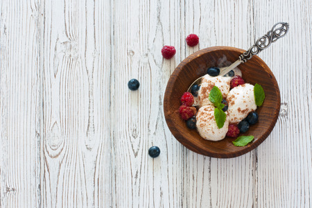 Vanilla ice cream with fresh berries over white wood background. Top view.の写真素材