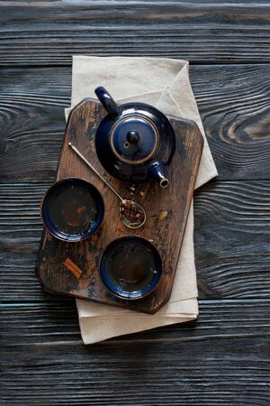 Teapot, teacup and Rooibos tea over black wood background. Top viewの写真素材