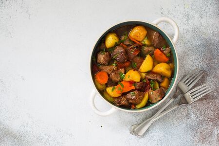 Beef stewed with vegetables on a stone  background. Flat lay. Copy spaceの写真素材