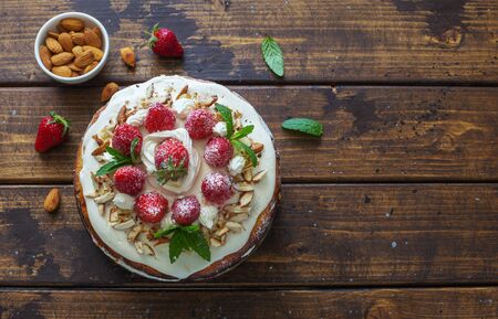 Delicious tart wih fresh strawberries and whipped cream on natural wooden background. Flat lay. Copy spaceの写真素材