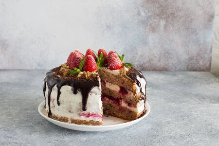 Delicious tart with cherries, almond flakes, chocolate topping  and whipped cream close up on a gray...