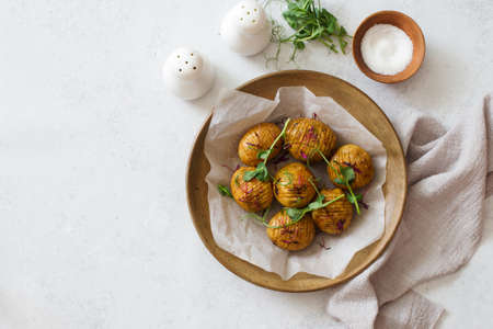 Oven baked hasselblad potatoes on clay rustic plate on gray stone background. Flat lay. Copy space