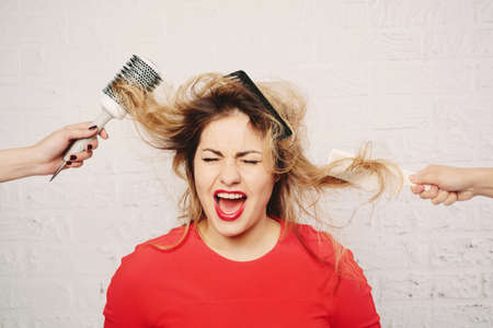 Funny casual Woman in hair salon. HairStyle Concept, expression, white brick wall backgroundの写真素材