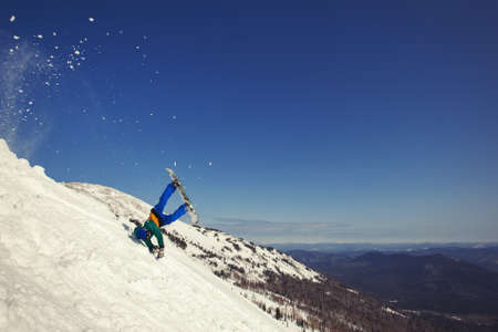 Snowboarder falling down in snow mountain