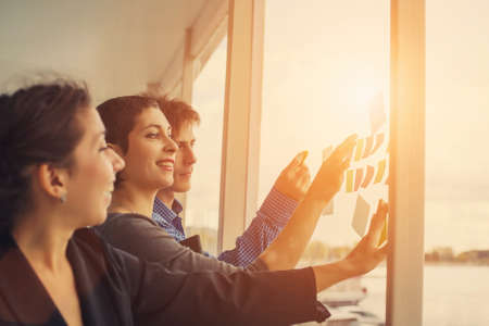 Happy Business team planning and discussing, use Stickers on big windowの写真素材
