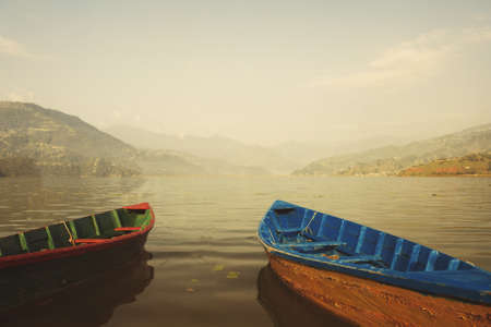 Couple boat on mountain lake. Morning fog, tranquil and calmの写真素材