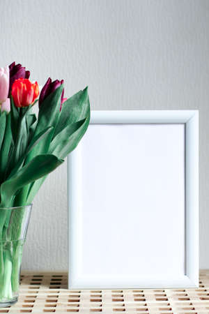 Poster with copy space. Mockup of a frame with tulips. White, minimalism. copy space.の写真素材