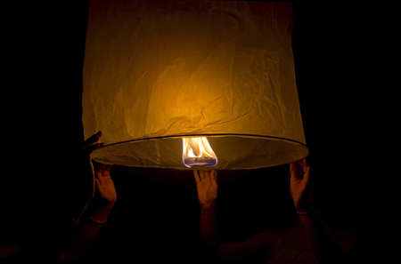 Two person launching lantern at nightの写真素材