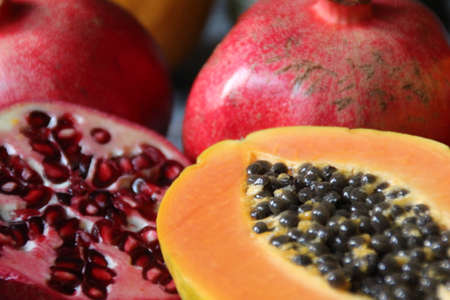 red and orange fruit, papaya and pomegranates, papaya cut in half