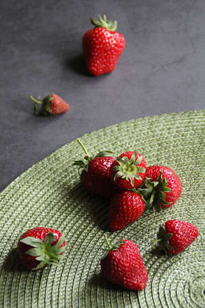 fresh strawberries, strawberries on a green pad, dark background, spring red fruits, strawberries...