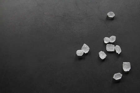 granulated sugar, sugar in the form of large crystals, crystals on a dark background