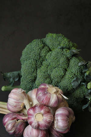 a bunch of garlic, a bouquet of garlic, fresh garlic and green broccoli, a large head of broccoliの写真素材