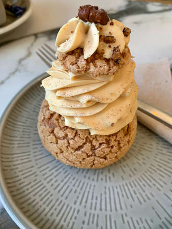 sugar puffs on a plate, puffs filled with creams, pistachio cream and cinnamon cream, two cookies on...