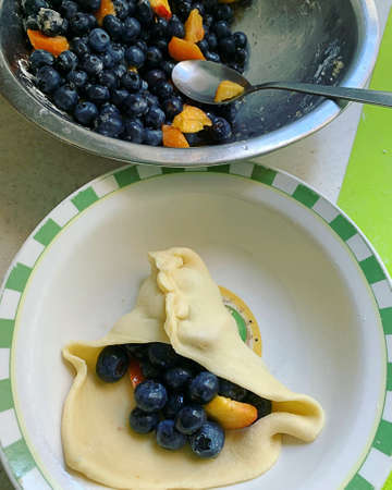 blueberries and apricots, prepared fruit for filling, stuffing dumplings dough, making fruit...