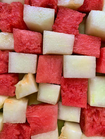melon and watermelon cut into squares, two-color grid made of diced fruit, red and white fruit grid, juicy fruit, natural vitaminsの写真素材