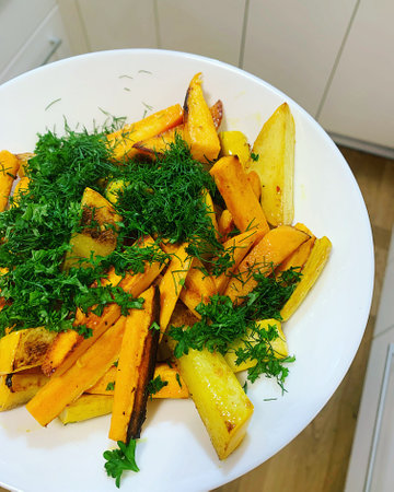 plate of yams and potatoes, sliced vegetables, fried yams and potatoes, vegetables sprinkled with...