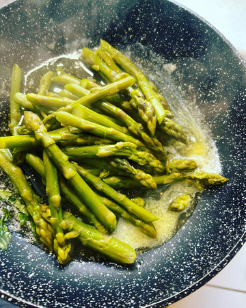green asparagus in a pan, preparing an asparagus dish, green vegetables, hot asparagusの写真素材