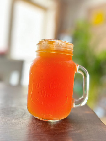 a glass with a cold drink, an orange drink, a cold aperol in a glass, a drink for warm daysの写真素材