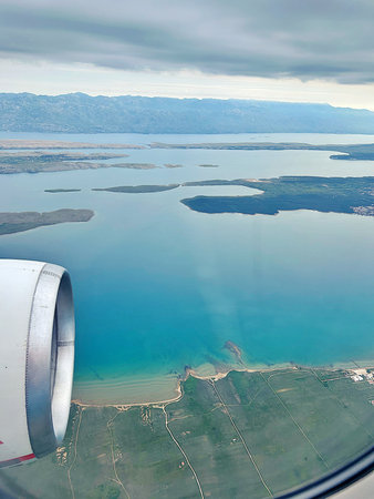 view from the plane to the sea, turquoise colors of the sea, plane engine, flight over the Croatian islandsの写真素材