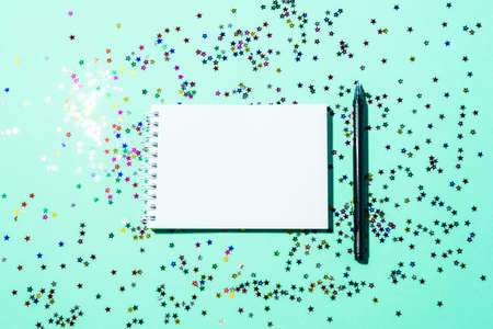 Notepad on a green festive background with shining stars