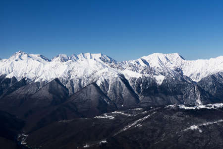 A mountain range covered with snow against a blue sky Caucasus mountains in winter