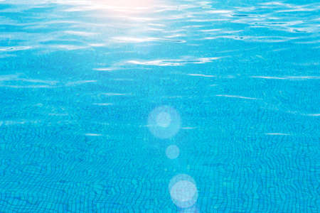 Blue pool surface pool water background with sun reflection abstract backgroundの写真素材