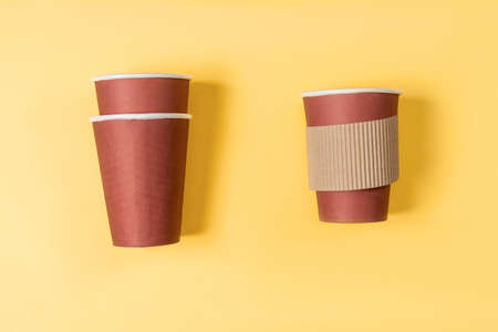 Disposable paper cup of coffee on a pastel yellow background Flat lay style Paper cup of coffee