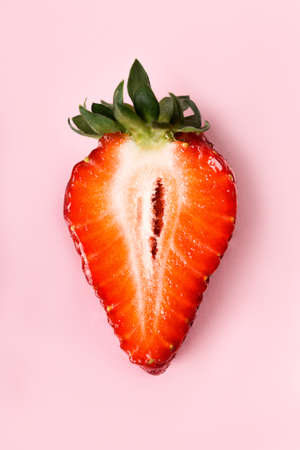 Beautiful juicy half strawberries on a pink background. Macro of sliced strawberries.の写真素材