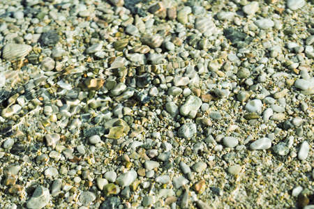 Pure clear sea water. The texture of sea stones.