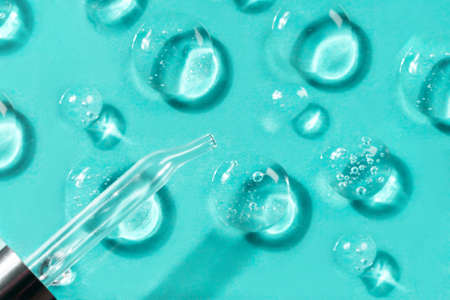 Pipette with drops of different forms of hyaluronic acid on a glass stand, blue background....