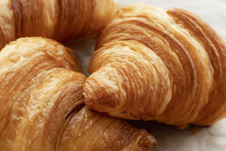 Fresh beautiful French croissants with jam on craft paper.の写真素材
