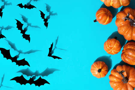 Halloween holiday concept. Pattern from paper bats of pumpkins and decor. Flat lay on blue background with copy space.の写真素材