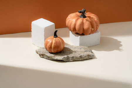 Creative Fall layout made of pumpkins. Halloween holiday concept. Pumpkins on a stone stand, orange background. Natural showcase.の写真素材