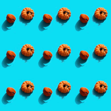 Autumn halloween holiday concept. Pattern from pumpkins. Flat lay on blue background.