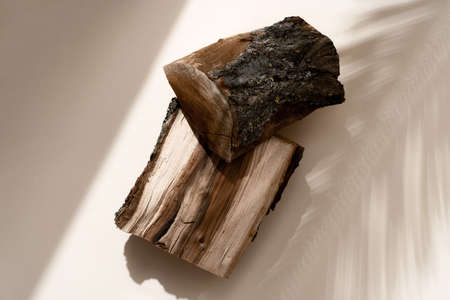 Natural wood podium with tropical leaves shadow in the background. Beautiful background from natural materials.の写真素材